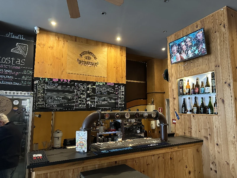 Interior bar area at Carmo Beer Bar Porto with wood paneling and brewery memorabilia on the walls