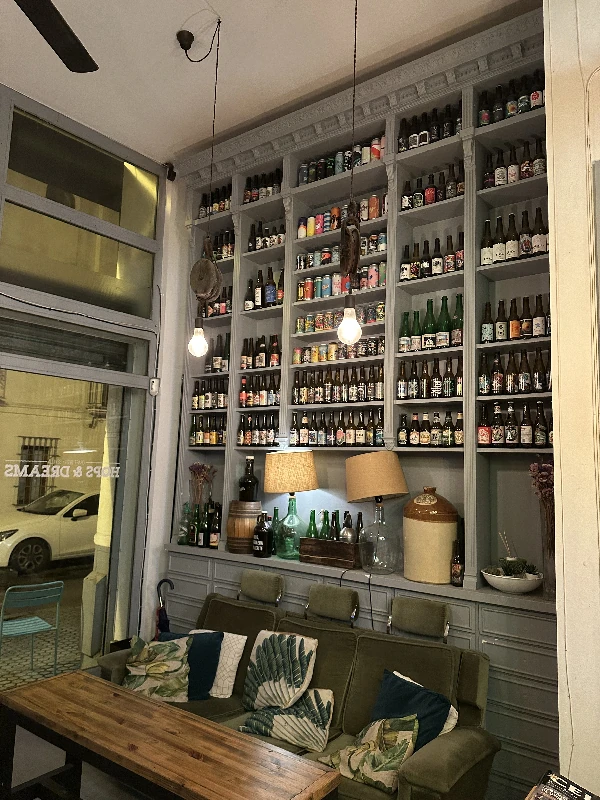 Wall of beer bottles and cans at Cervecería Hops and Dreams Seville