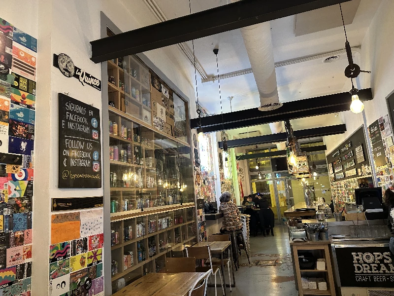 Interior of Cervecería Hops and Dreams Seville with beer label décor covering the walls